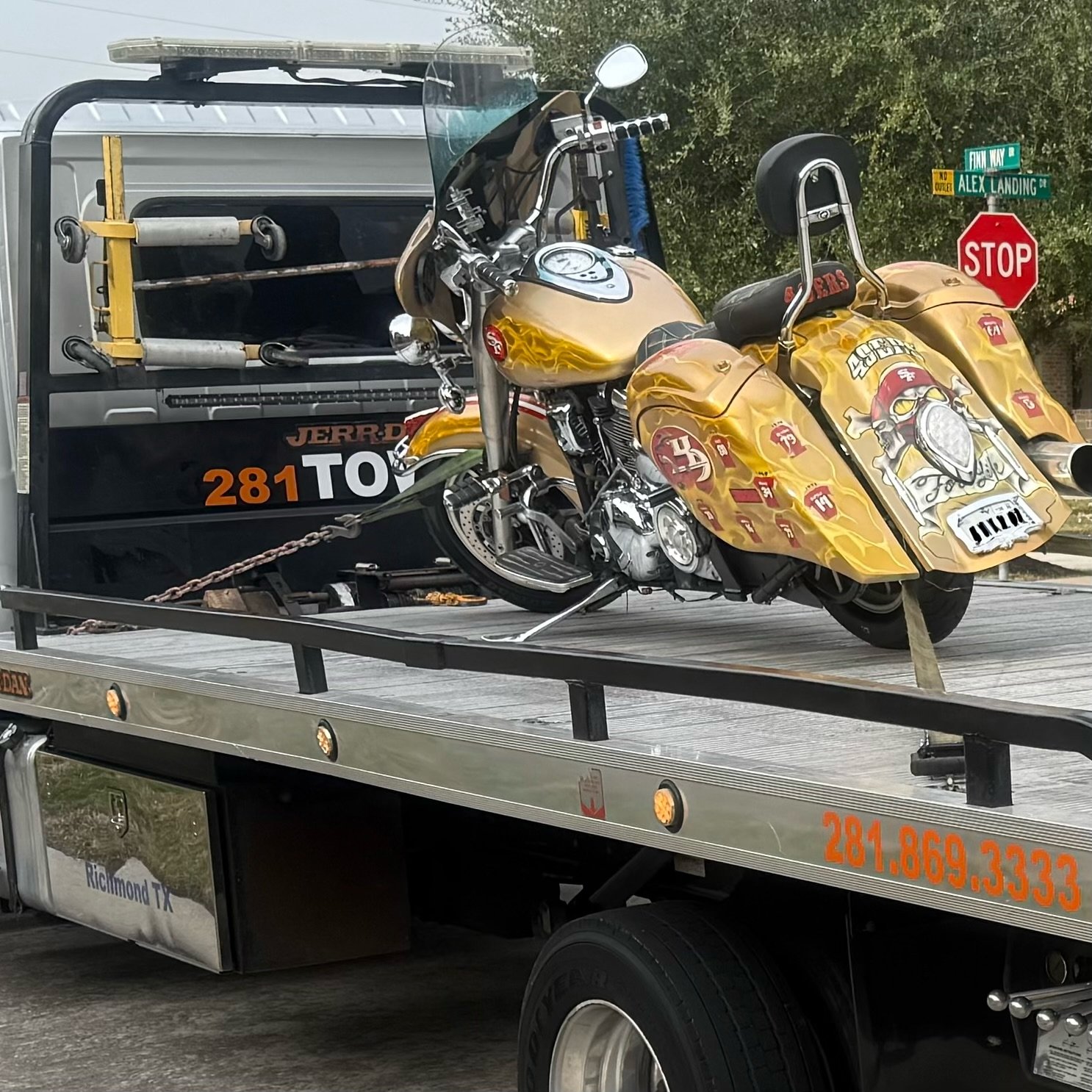 Yellow motorcycle secured on a tow truck's flatbed in Richmond, Texas